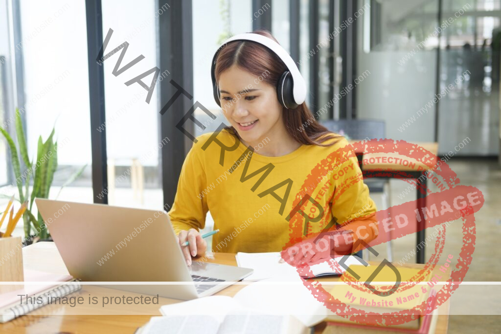 Woman learning online using laptop and writing notes.