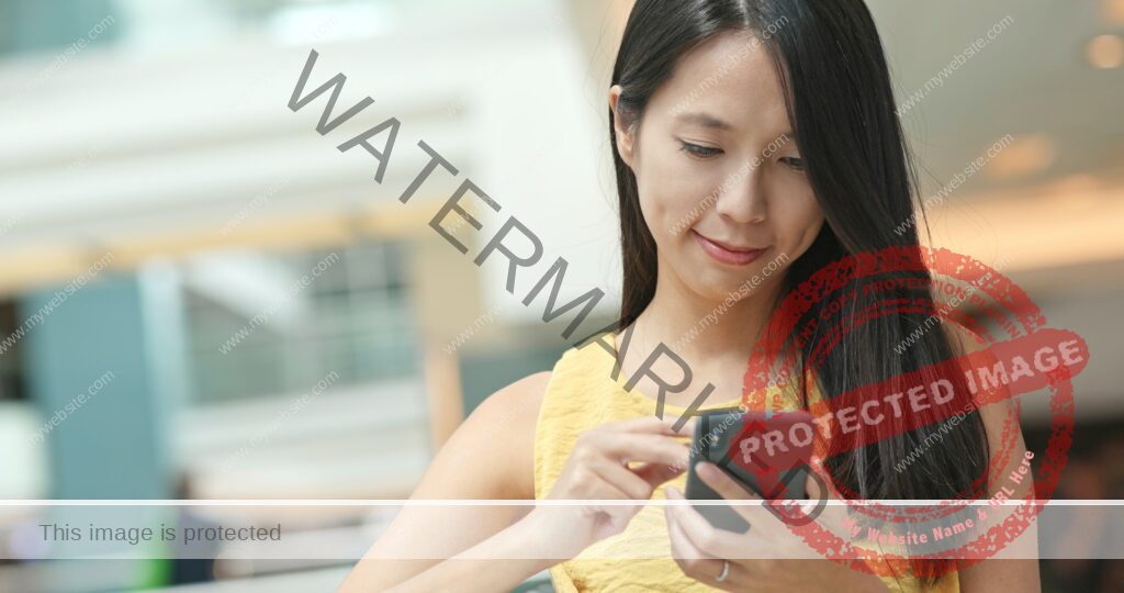 Woman sending sms on cellphone in shopping mall